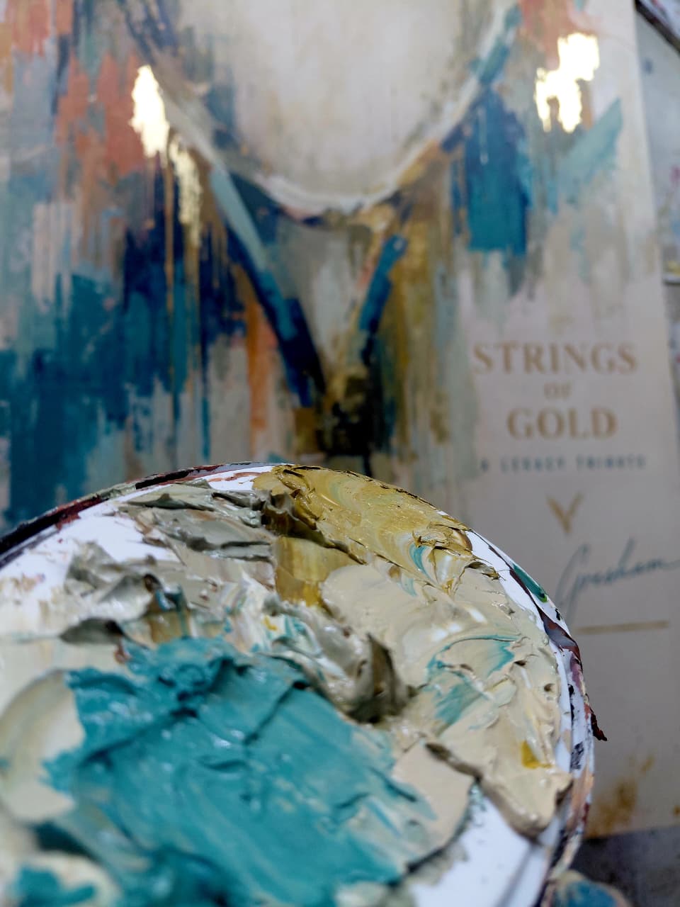 Strings of Gold legacy artwork in progress, palette of teal and gold oil paint in the foreground